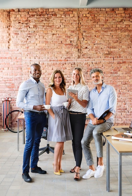 Foto portret van lachende collega's aan bureau in loft kantoor