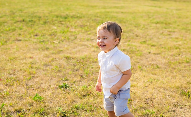 Portret van lachende gelukkige babyjongen op natuurlijke achtergrond in de zomer.