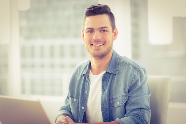 Portret van lachende jonge man met laptop