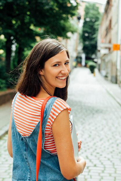 Portret van lachende jonge vrouw in de stad