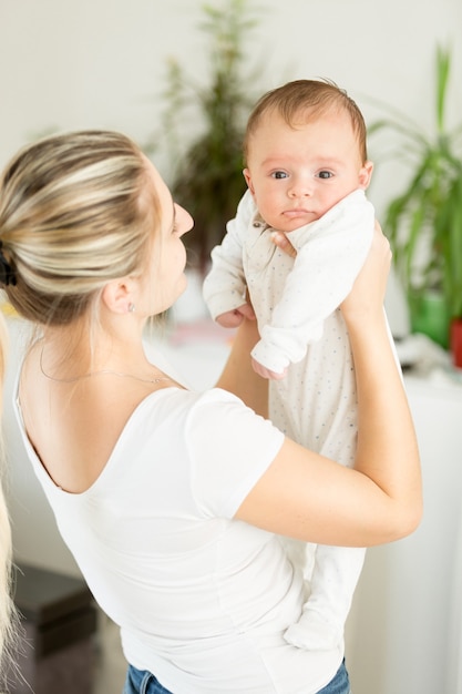 Portret van lachende moeder die haar babyjongen vasthoudt