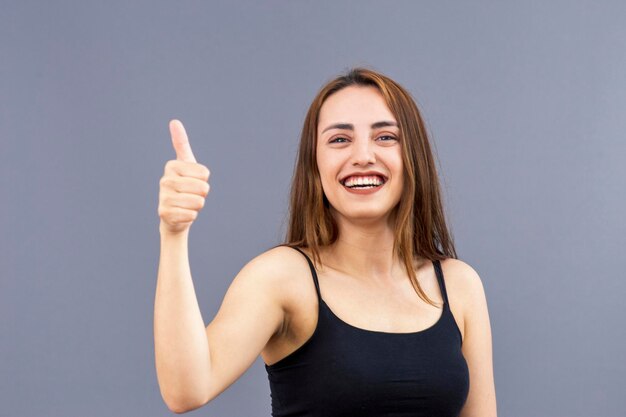 Portret van lachende mooie Turkse jonge vrouw maakt goed gebaar geeft overeenstemming aan en dat alles in orde is met warme en positieve stemming geweldige emoties Gebaren en emoties concept