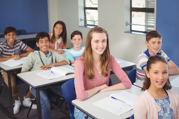 Portret van lachende schoolkinderen zitten in de klas