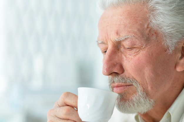 Portret van lachende senior man die koffie drinkt