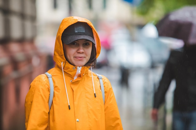 Portret van lachende vrouw in gele regenjas