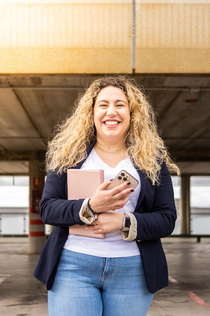 Portret van lachende vrouwelijke ondernemer in formele pak met tablet en koffie buitenshuis Jong smart casual kleding zakenvrouw portret