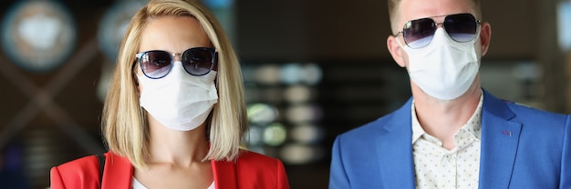 Portret van man en vrouw die medische beschermende maskers dragen