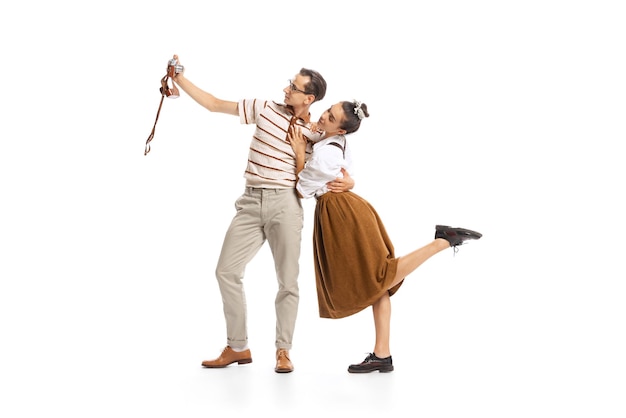 Portret van man en vrouw poseren nemen selfie met vintage camera geïsoleerd op een witte achtergrond