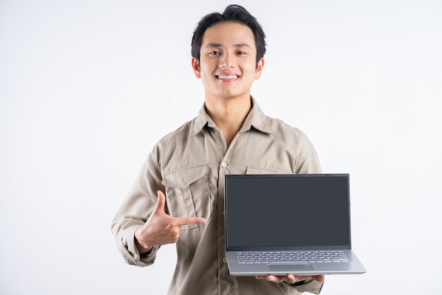 Portret van mannelijke monteur permanent met laptop en erop gericht op wit