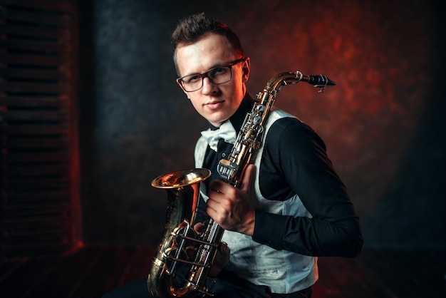 Portret van mannelijke saxofonist met saxofoon, jazzman met saxofoon.