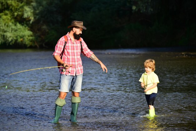 Portret van mannen van twee generaties die aan het vissen zijn Kleine jongen die met vader aan het vissen zijn Generaties leeftijden vader en zo