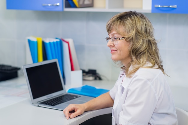 Portret van medisch deskundige op het werk met behulp van laptop