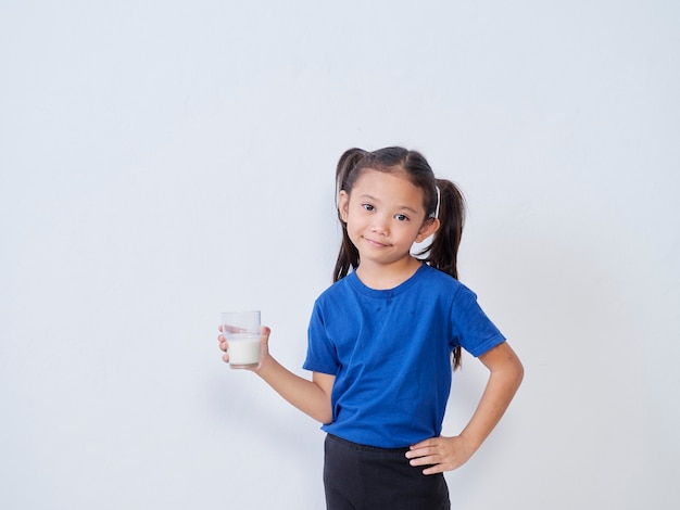 Portret van meisje met glas melk op licht