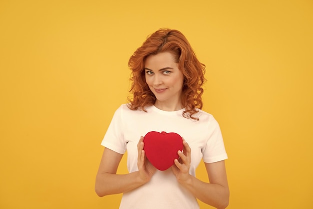 Portret van meisje met hart gelukkige Valentijnsdag wees mijn Valentijnsdame op gele achtergrond