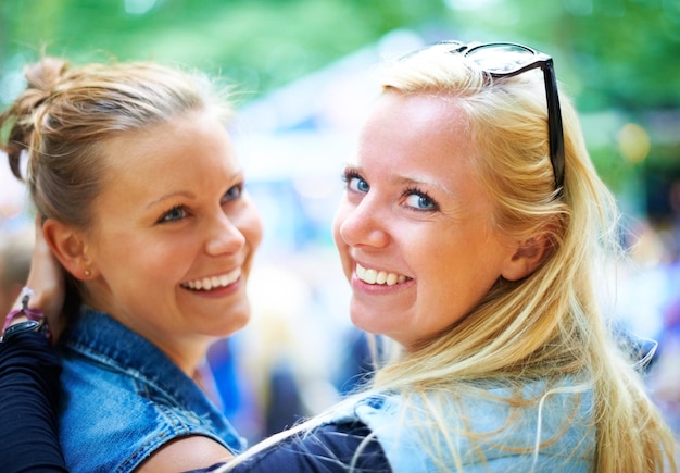 Portret van meisjes en gelukkige vrienden op een muziekfestival, een evenement in de buitenlucht of een band op een concert. Zonnebril of vrouwen samen op een feestje voor een feest, carnaval of glimlach van mensen die plezier hebben in de natuur.