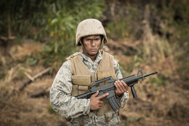 Portret van militaire soldaat bewaken met een geweer in een laarskamp