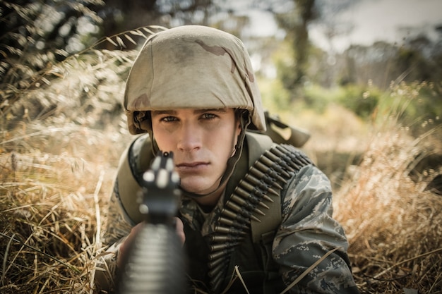 Portret van militaire soldaat gericht met een geweer in laarskamp