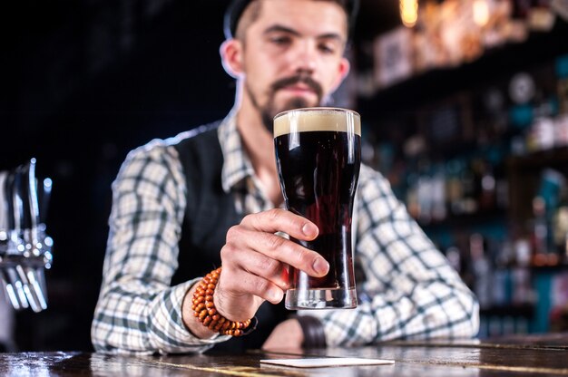 Portret van mixoloog demonstreert zijn vaardigheden over de toonbank in de bar