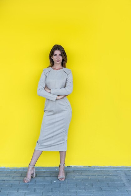 Portret van mode mooie jonge vrouw in beige pak geïsoleerd van gele background