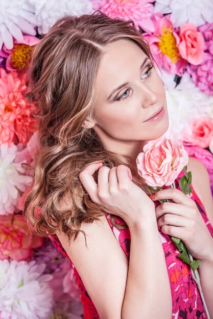 Portret van mode mooie vrouw, lief en sensueel met luxe make-over en haren op de achtergrond kleuren bloemen