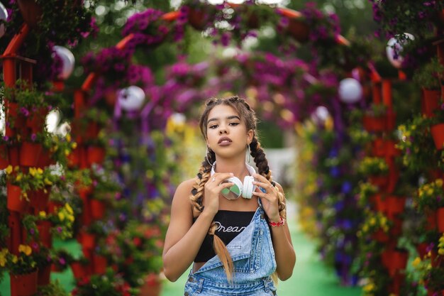 Portret van moderne tienermeisje met koptelefoon Bloeiende bloemen op de achtergrond