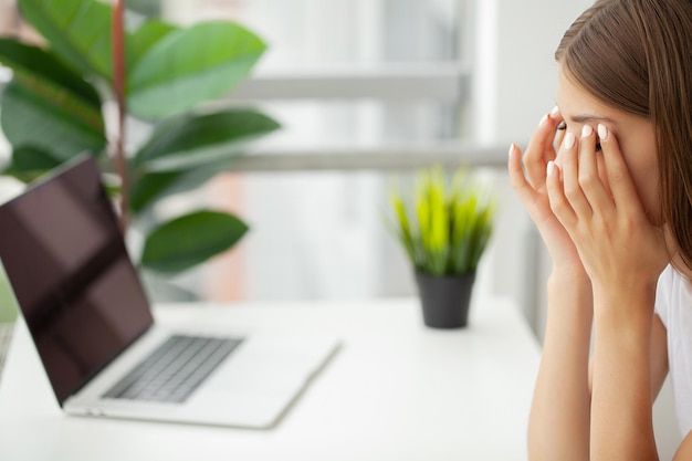 Portret van moe jonge zaken vrouw met laptopcomputer