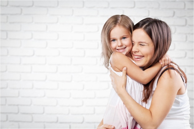 Portret van moeder en dochter knuffelen en glimlachen