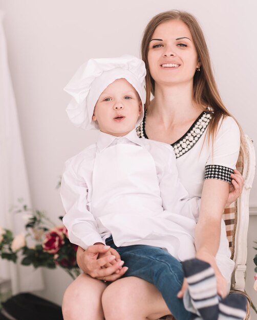 Portret van moeder en haar zoontje in een kokskostuum die samen zitten