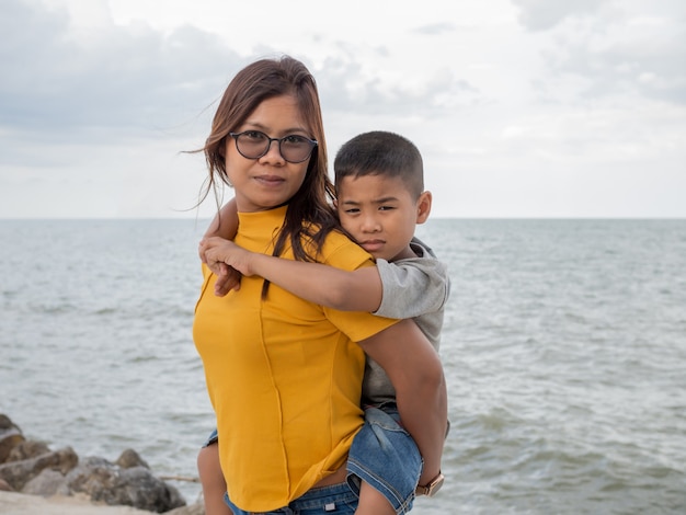 Portret van moeder en zoon op de achtergrond van een zee