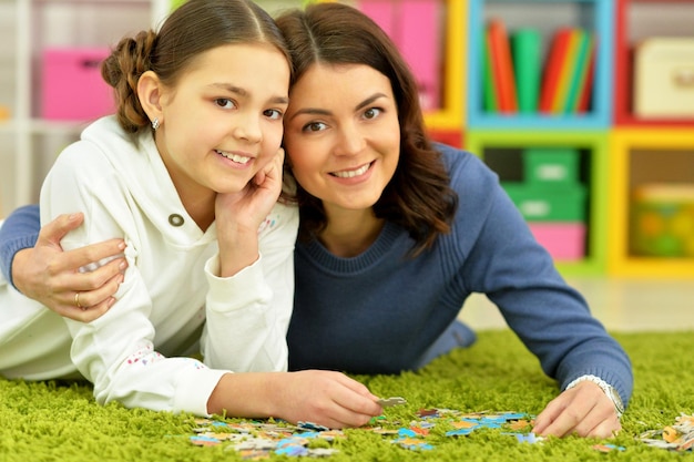 Portret van moeder met dochtertje die puzzels verzamelt