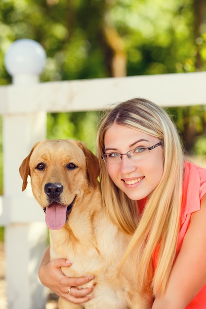 Portret van Mooi jong meisje met haar hondlabrador retriever openlucht in de zomer mooi park