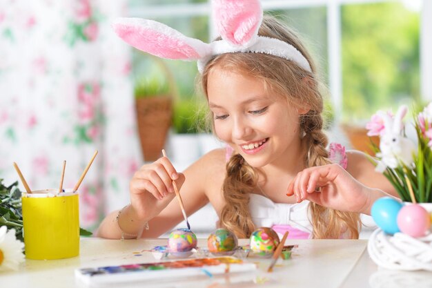 Portret van mooi meisje dat eieren schildert voor paasvakantie