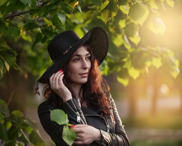 portret van mooi meisje in donkere kleding en zwarte hoed op zonsondergang Kunstwerk romantische woman