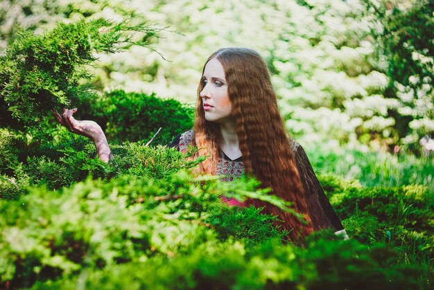 Portret van mooi meisje, jonge vrouw met lang rood haar, sproeten. Vintage jurk. lentetuin