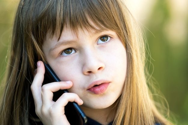 Portret van mooi meisje met lang haar praten op mobiele telefoon