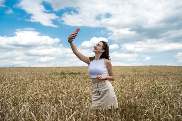 Portret van mooi meisje poseren in tarweveld genieten van zomertijd. vrijheid