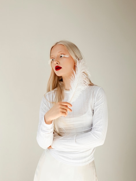 Foto portret van mooie albinovrouw met witte veer