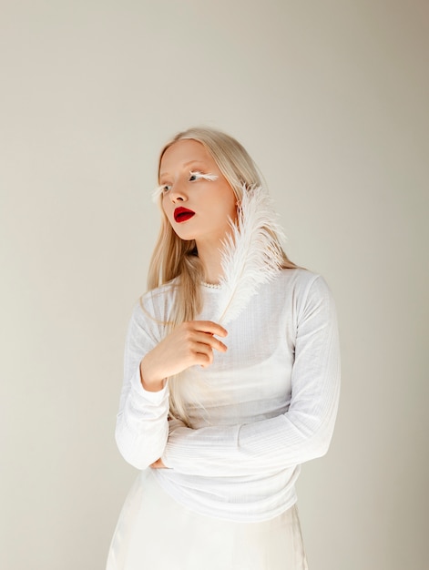 Portret van mooie albinovrouw met witte veer