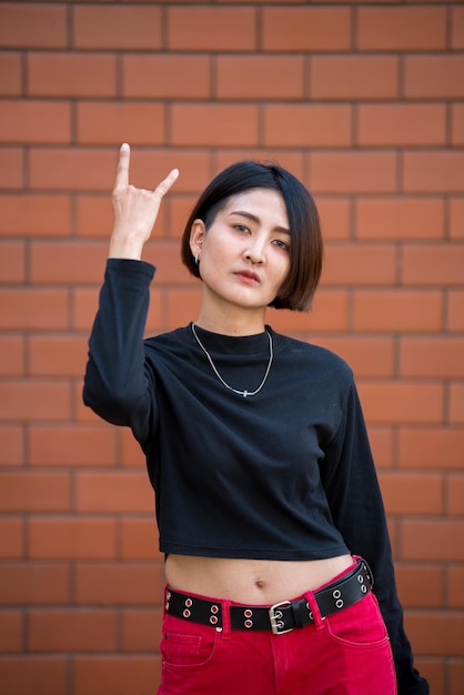 Portret van mooie Aziatische chique meisje poseren voor het nemen van een foto op muur achtergrondLifestyle van tiener thailand mensenModerne vrouw gelukkig conceptPunk rock stijl