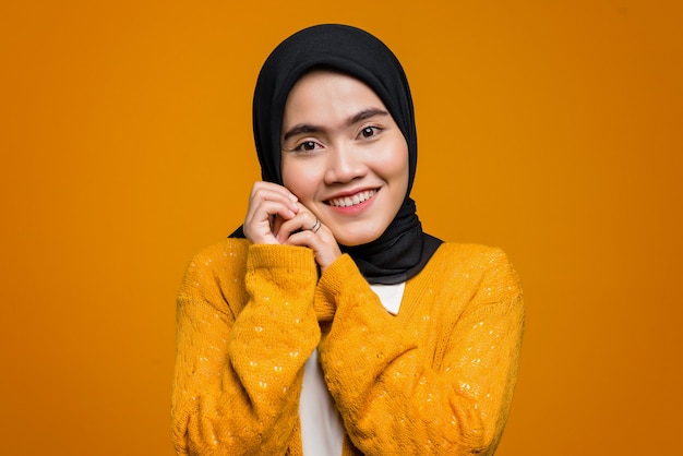 Portret van mooie Aziatische vrouw die en een geel vest glimlacht draagt
