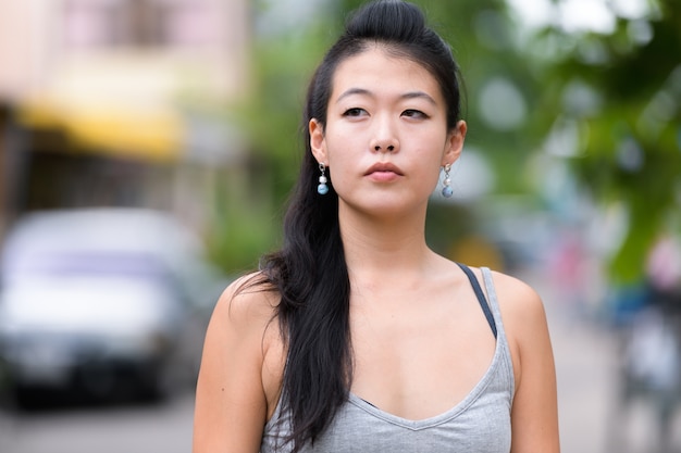 Portret van mooie Aziatische vrouw in de straten buiten