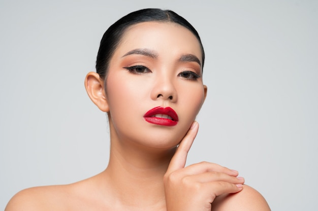 Portret van mooie Aziatische vrouw met zwart haar en rode lippen