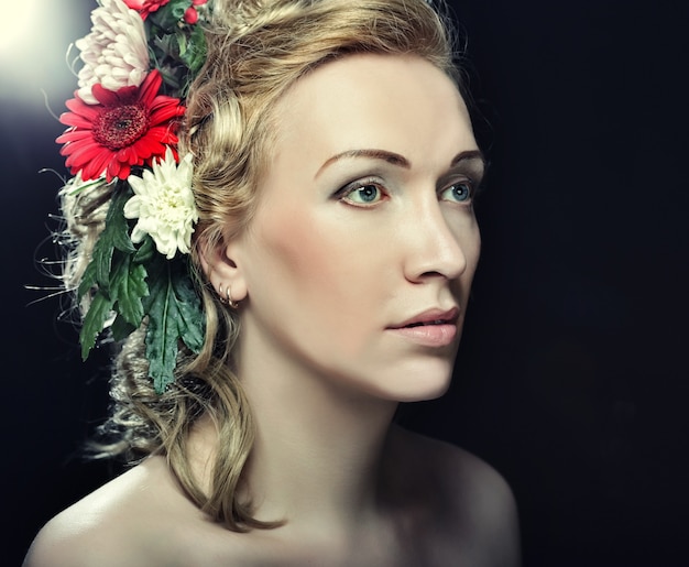 Portret van mooie blonde vrouw met bloemen in haar haar