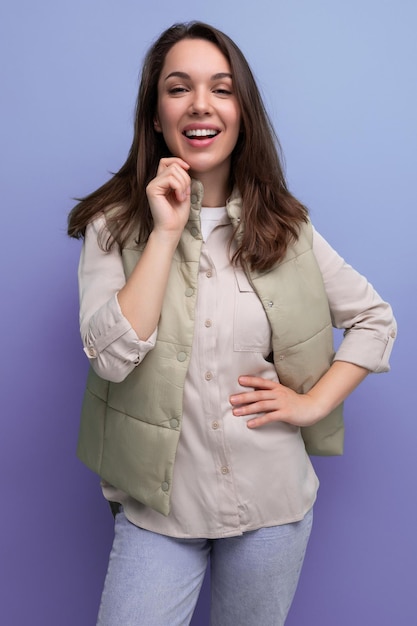 Portret van mooie donkerbruine jonge vrouw in overhemd en jeans met haarstyling