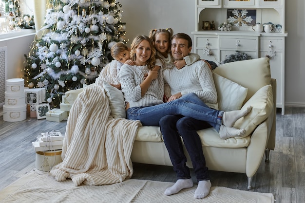 Portret van mooie gelukkige familie met twee kinderen in witte truien