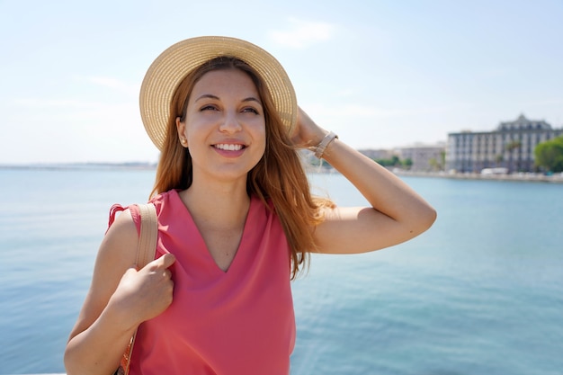 Portret van mooie glimlachende vrouw die naar de kant op zee in de stad kijkt
