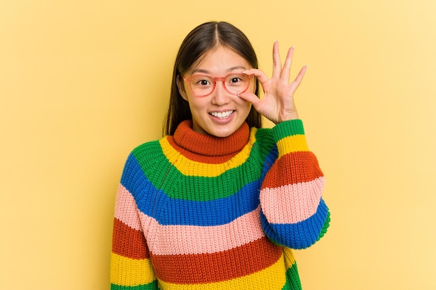 Portret van mooie jonge Aziatische vrouw geïsoleerd op gele background