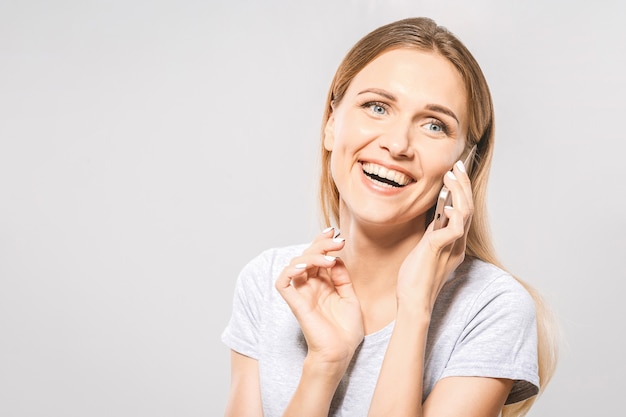 Portret van mooie jonge casual vrouw met behulp van mobiele telefoon geïsoleerd op een witte achtergrond