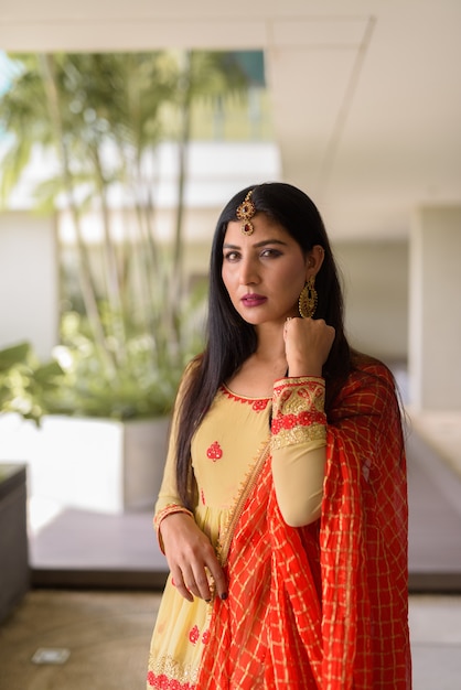 Portret van mooie jonge Indiase vrouw die buiten traditionele kleding draagt