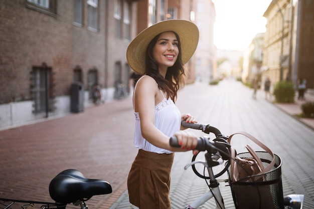 Portret van mooie jonge vrouw die geniet van tijd op de fiets in stedelijk gebied